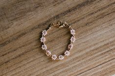 "This gold and pink flower beaded baby bracelet is so perfect for a baby shower gift or first birthday. Made with quality gold filled beads and materials that last with the right care. We highly recommend measuring your wrist for the best fit. Take a measuring tape and measure wrist tightly around (in inches). Add 1/2 inch and that's the size you should order.  Newborn: 3.5\" 0-6 months: 4\" 6-12 months: 4.5\" 1-3 years: 5\" 3-6 years: 5.5\" 6-12 years: 6\" Ladies XS, 6.5\" Ladies S, 7\" Ladies M, 7.5\" Ladies L, 8\" Ladies XL, 8.5\" Anklet XS, 8 Anklet S, 8.5 Anklet M, 9 Anklet L, 9.5" Cute Handmade Gold Beaded Bracelets, Gold Flower Jewelry With Tiny Beads, Gold Floral Jewelry With Tiny Beads, Gold Flower-shaped Jewelry With Tiny Beads, Gold Flower Jewelry With Gold Beads, Gold Floral Jewelry With Gold Beads, Gold Flower-shaped Jewelry With Gold Beads, Dainty Pink 14k Gold-filled Bracelets, Dainty Pink 14k Gold Filled Bracelets