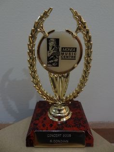 an award is displayed on top of a red and gold pedestal with a plaque in the middle