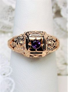 Natural Amethyst Ring Description Garden Wedding Design#157 MADE TO ORDER Here we have an Edwardian reproduction wedding ring in sterling silver & rose gold filigree with a natural amethyst gemstone solitaire. This full cut round purple amethyst is 2.5mm in diameter. The setting is 8mm NS on the finger. The inside of the band is marked 925 for sterling. Notice the beautiful floral garden design of the filigree setting. This is a lovely rendition of a 1910's Antique filigree wedding ring, and it Filigree Wedding Ring, Ring Rosegold, Antique Filigree, Purple Amethyst Ring, Order Design, Amethyst Gem, Purple Band, Sterling Silver Filigree, Filigree Ring