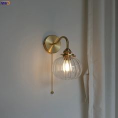 a wall light that is on the side of a wall next to a white curtain