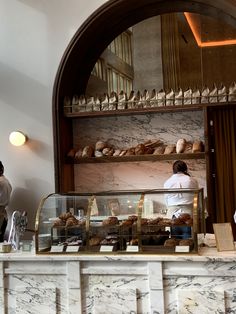 a bakery with marble counter tops and shelves filled with pastries