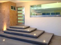 concrete steps lit up with lights in front of a wall and window on the side