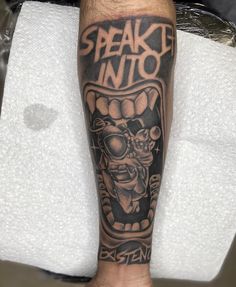 a man with a tattoo on his leg that says speak out into the air and an image of a demon