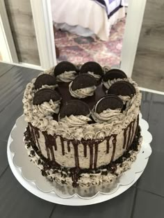 a cake with oreo cookies and cream frosting sitting on top of a table