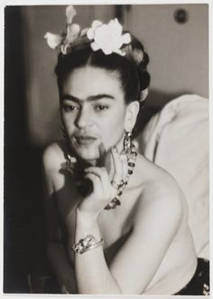 an old black and white photo of a woman with bracelets on her head posing for the camera