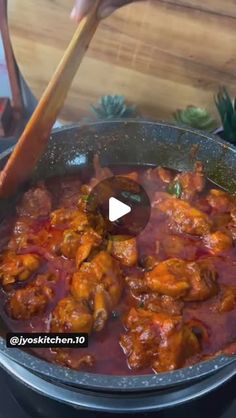 someone is stirring some food in a pot with a wooden spoon on the stove top