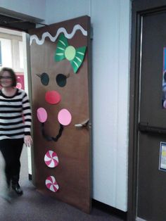 a woman standing in front of a door decorated like a gingerbread man