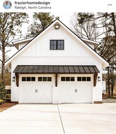 a white house with two garages and a black awning on the front door