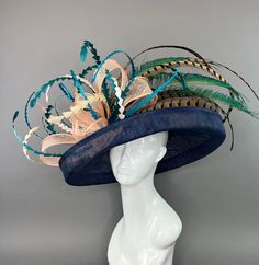 Navy Blue flipped brim hat adorned with peacock spines. Coordinated with shades of teal and turquoise feathers. Fits crown size of 22.5" with internal elastic band to create a snug and comfortable fit for crown sizes smaller than 22.5". Please measure prior to purchasing as all sales are final. Don't forget to follow us on Instagram @ TheHatHive Blue Spring Hat With Structured Crown, Blue Structured Crown Hat For Spring, Spring Blue Hat With Structured Crown, Blue Feather Trim Mini Hat For Kentucky Derby, Blue Mini Hat With Feather Trim For Kentucky Derby, Adjustable Blue Hat For Royal Ascot, Adjustable Blue Hat For Kentucky Derby, Adjustable Blue Costume Hats For Royal Ascot, Blue Hat With Feather Trim For Spring