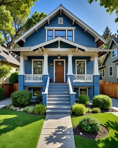 a blue house with white trim on the front porch and steps leading up to it