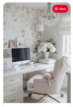 a white chair sitting in front of a desk with a computer on top of it