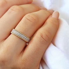 a woman's hand with a wedding ring on her left and an engagement band on her right