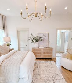 a large white bed sitting in a bedroom on top of a hard wood flooring