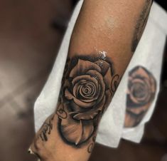 a black and white rose tattoo on the arm