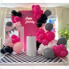 a birthday party with balloons, checkered table cloths and black and white decor