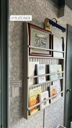 there is a book shelf with books on it in the room that has wallpaper