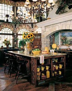 a large kitchen with an island in the middle and sunflowers hanging from the ceiling