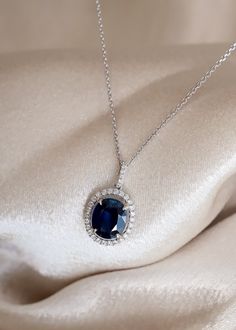 The beautiful blue color of this Sapphire gemstone makes this necklace a true show-stopper. We've set this 2.90ct Oval Cut Blue Sapphire in a White Gold pendant with a 0.29ctw Diamond Halo. Looking for a memorable birthday or anniversary gift? This bold pendant is perfect! Details: Gemstone: Sapphire Metal: 14K White Gold Chain, 18K White Gold Setting Gem Color: Blue Weight: 2.90ct Sapphire, 0.29ctw Diamond Gem Cut: Oval Quality: 100% Natural Gemstone 32 x 0.29ctw Diamond Halo Certified Blue Sapphire We can design any gemstone pendant specified in your style. Our inventory of gemstones makes it easy to design a masterpiece within your budget. Feel free to text us directly at 972-404-4499 to speak with a jewelry specialist. Want to see more photos📷 and videos 🎥 of our jewelry? Follow us o Blue Sapphire Diamond Pendant, Blue For Wedding, Blue Sapphire Pendant, Blue Sapphire Necklace, Wedding Day Jewelry, White Gold Chain, White Gold Pendant, Blue Sapphire Diamond, Sapphire Pendant