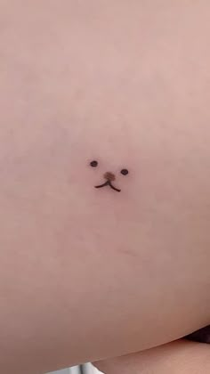 a woman's stomach with a small face drawn on the side and two black eyes