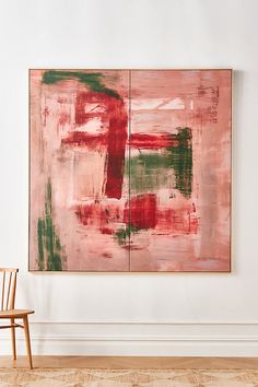 an abstract painting hangs on the wall next to a wooden chair