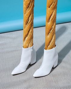 a pair of white high heeled boots with braids on the legs and ankles