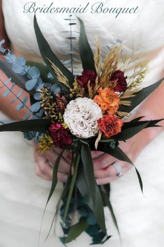 a bridal bouquet is being held by a woman in a white wedding dress with red and orange flowers