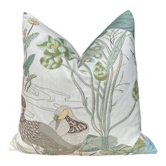 a white pillow with birds and flowers on it