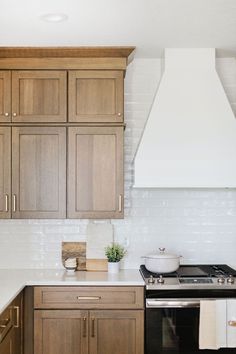 a stove top oven sitting inside of a kitchen next to wooden cupboards and counter tops