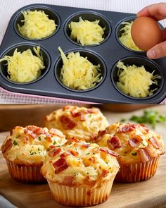 a person holding an egg in a muffin tin next to some bacon and cheese muffins