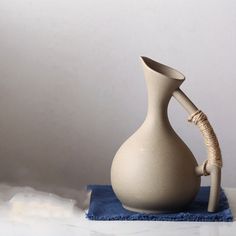 a white vase sitting on top of a blue towel