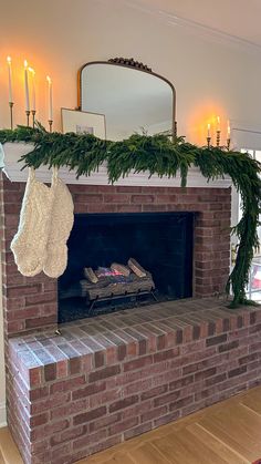 a brick fireplace with stockings hanging from it's mantle and candles in the background