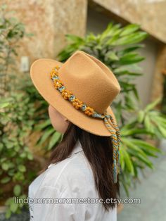 a woman wearing a tan hat with beads on it