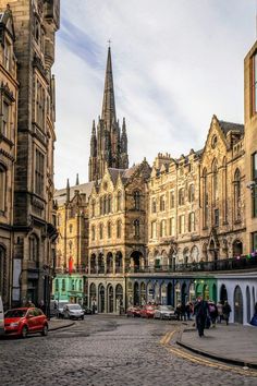 an old city street with cars parked on the side