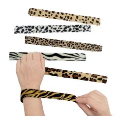 several different types of animal print headbands being held by someone's hand