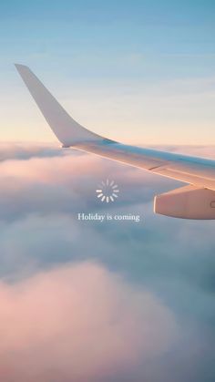 an airplane is flying above the clouds with a holiday card on it's wing