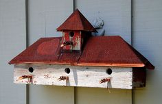 a bird house with four birds perched on it's roof