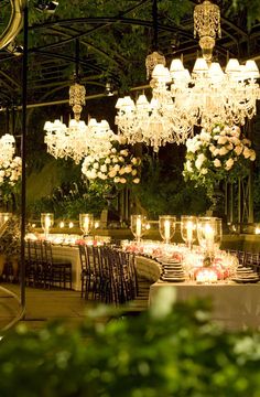 an outdoor dining area with chandeliers and tables set up for a formal function