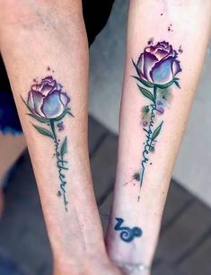 two people with matching tattoos on their legs, one is holding the other's hand