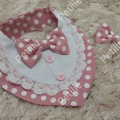 a pink and white polka dot baby bib with matching hair clips