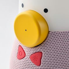 a yellow ducky head on top of a pink dress with hearts and dots around it