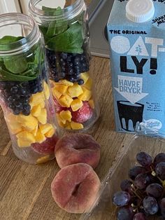 fruit and yogurt are sitting on a table next to a carton of milk