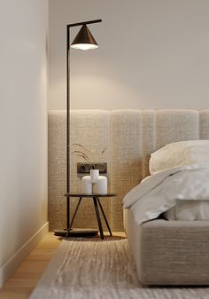 a white bed sitting next to a tall lamp