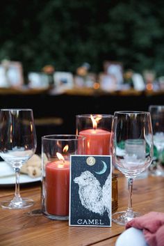 candles and wine glasses on a wooden table