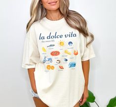 Get ready to be OBSESSED with your La Dolce Vita Shirt! This shirt is the cutest and most trendy way to emit all those Italian American vibes! This is the perfect soft tee to throw on for a Sunday dinner at Nonna's! Also makes a great gift for your cugina! This design is an original, created by Jackie Bonsignore @ Drift East Designs. She uses digital design elements and collage. She optimizes each image or illustration for a crisp, clear and gorgeous print onto a variety of apparel.  * Q U I C K * F A C T S * ✺ This is a Comfort Colors T-shirt, known for exceptional construction, softness, and durability, using only high-quality, USA-grown ring-spun cotton. ✺ 100% preshrunk cotton (fiber content may vary for different colors) ✺ Wash and dry normally (on cool for best results) ✺ Please note Tomato Girl Summer, Italian Sayings, American Vibes, Tomato Girl, Italy Shirt, Italian Theme, Italian Gifts, Italian Pride, Italian Shirts