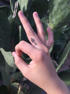 a person's hand with a small tattoo on their left thumb and the word love written in black ink