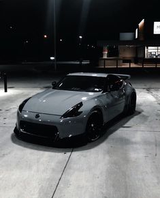 a silver sports car parked in an empty parking lot