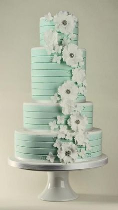 a three tiered cake with white flowers on top