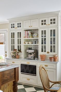 a kitchen with white cabinets and black and white checkered flooring on the floor