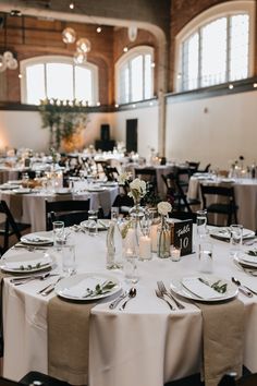 the tables are set with white linens and place settings