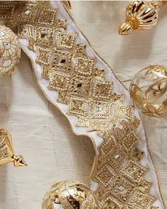 some gold ornaments are laying on a white table cloth and it looks like they have been made out of fabric